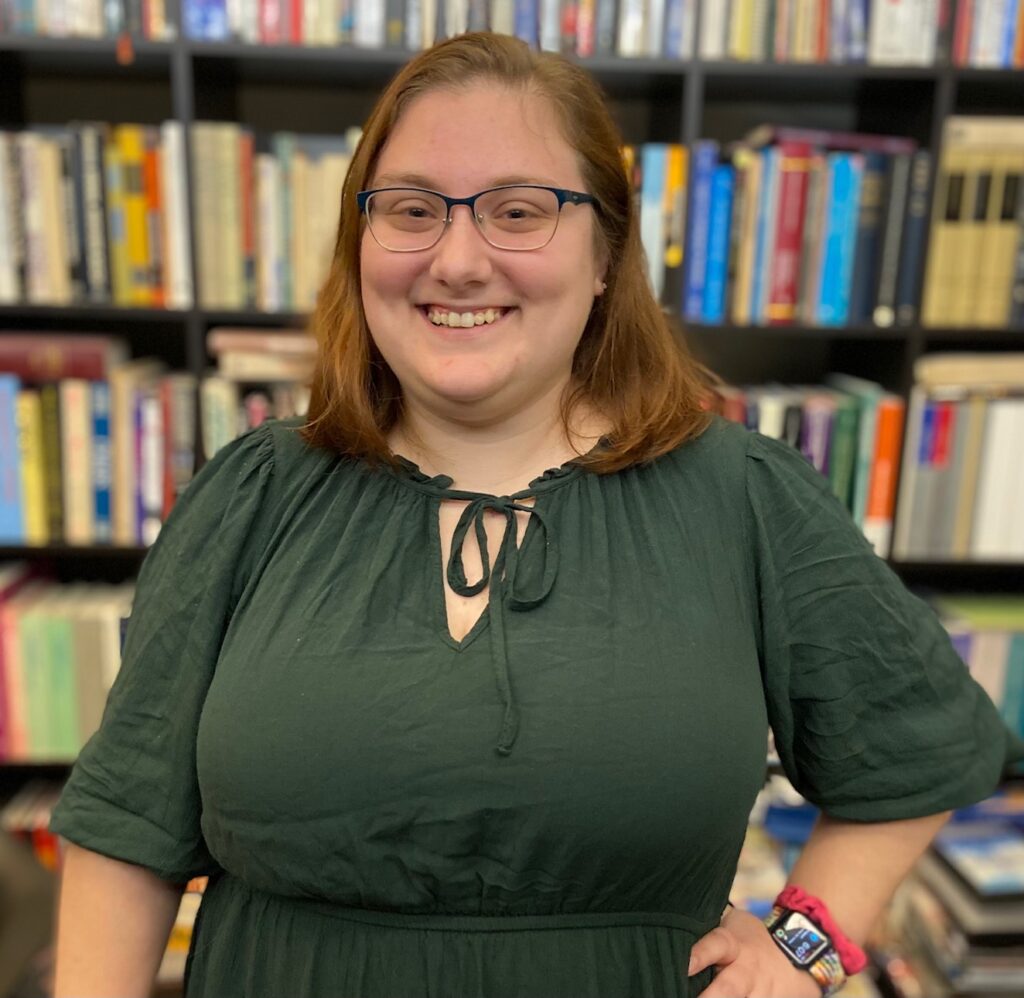 A white woman wearing a green dress is smiling at the camera